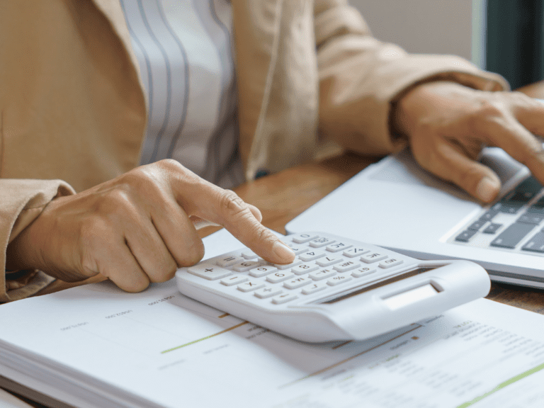 Woman using a calculator to estimate website design costs and project expenses.